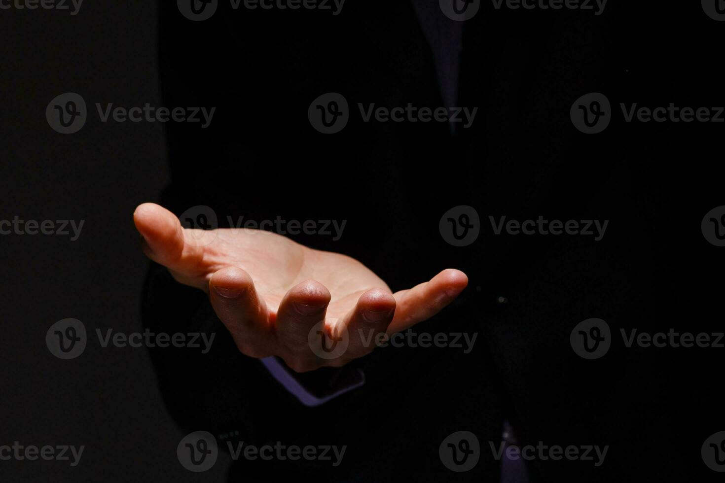 Businessman in blue suit presenting empty palm - it can be used to advertise product on his hands. photo
