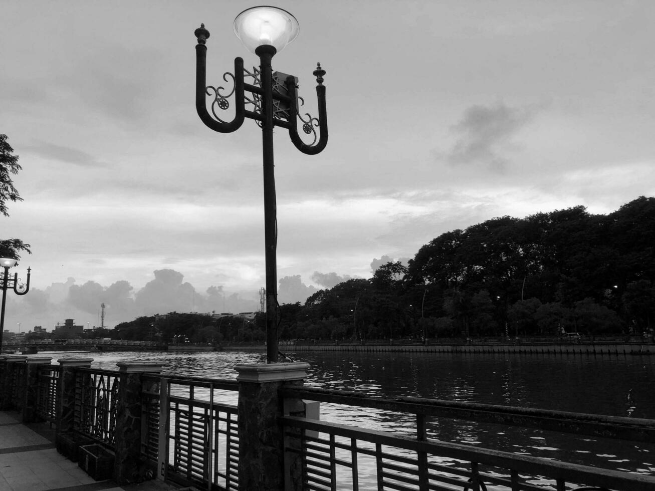 silueta en el puesta de sol por el río negro y blanco fotografía foto