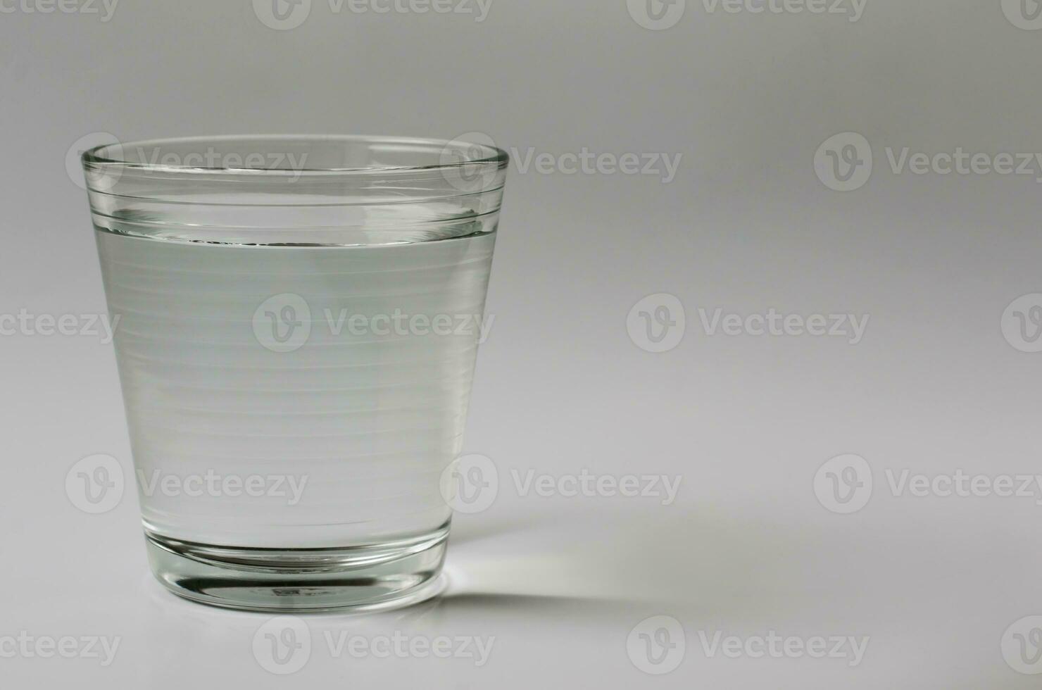 Glass of Drinking Water on Clear Background for Copy Space photo