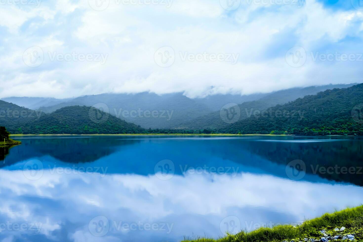 Beautiful landscape with mountains dramatic lake in the fog reflection of sky and cloud in water photo
