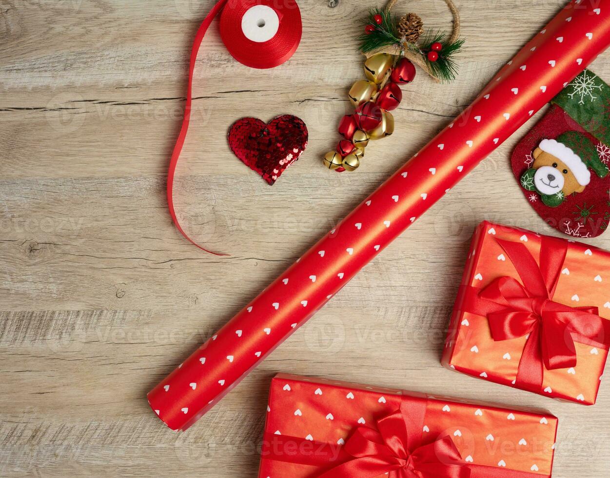 Christmas decor, gifts wrapped in red paper on a wooden background, top view. photo