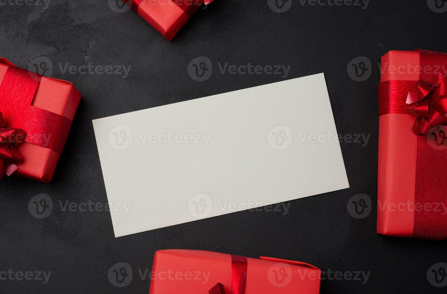 Boxes packed in red paper and tied with ribbon on a black background, gifts photo