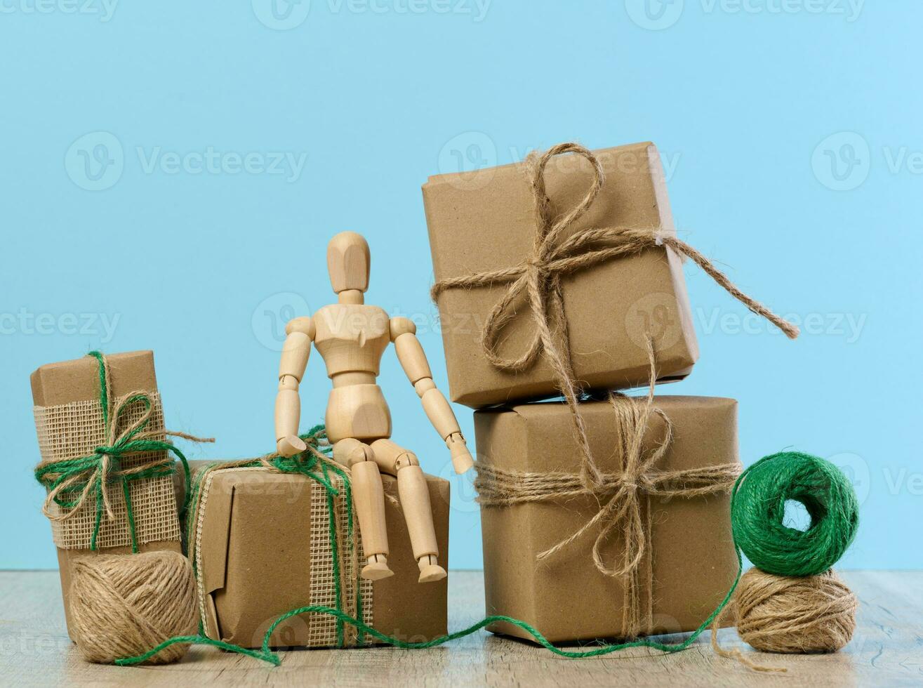 The box is packed in brown craft paper and tied with a rope on a blue background, gift photo