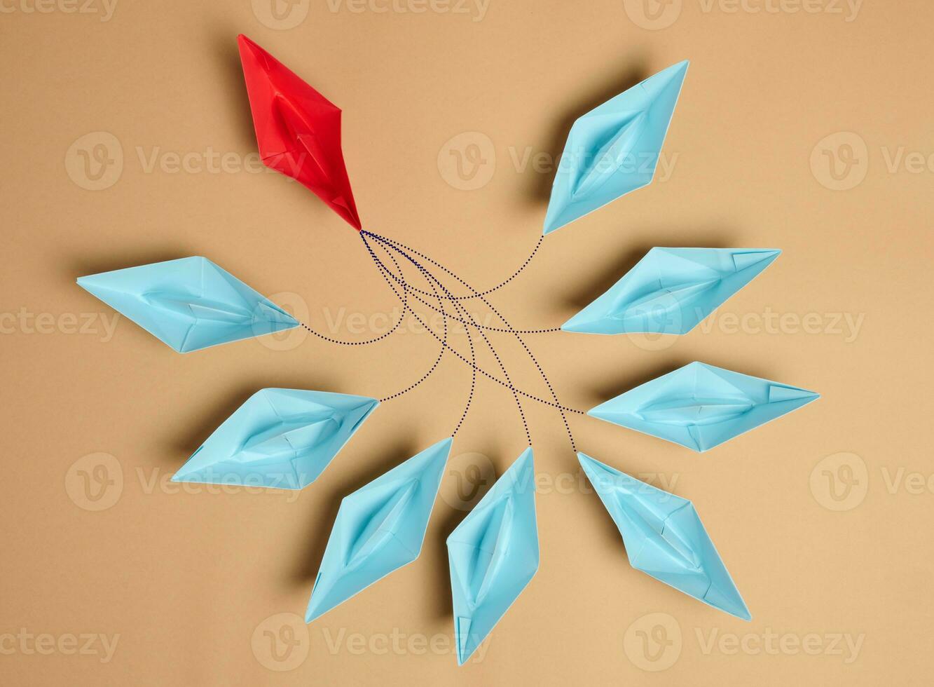 Group of paper boats on a brown background.Concept of a strong leader in a team, manipulation of the masses, following new perspectives photo