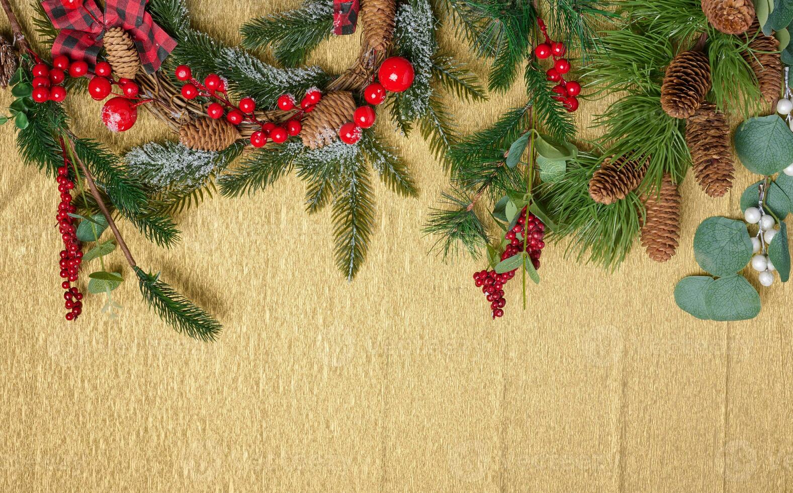 Christmas wreath made of fir branches and other decorations on a yellow background, copy space photo