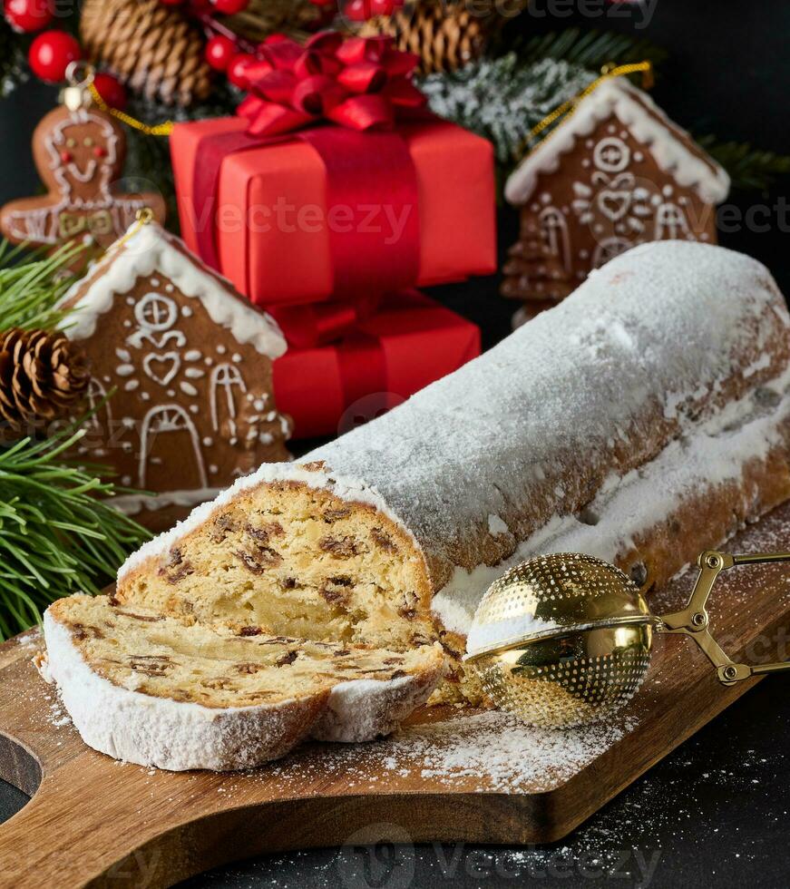 Navidad pasteles Stollen rociado con en polvo azúcar en el mesa, festivo postre foto