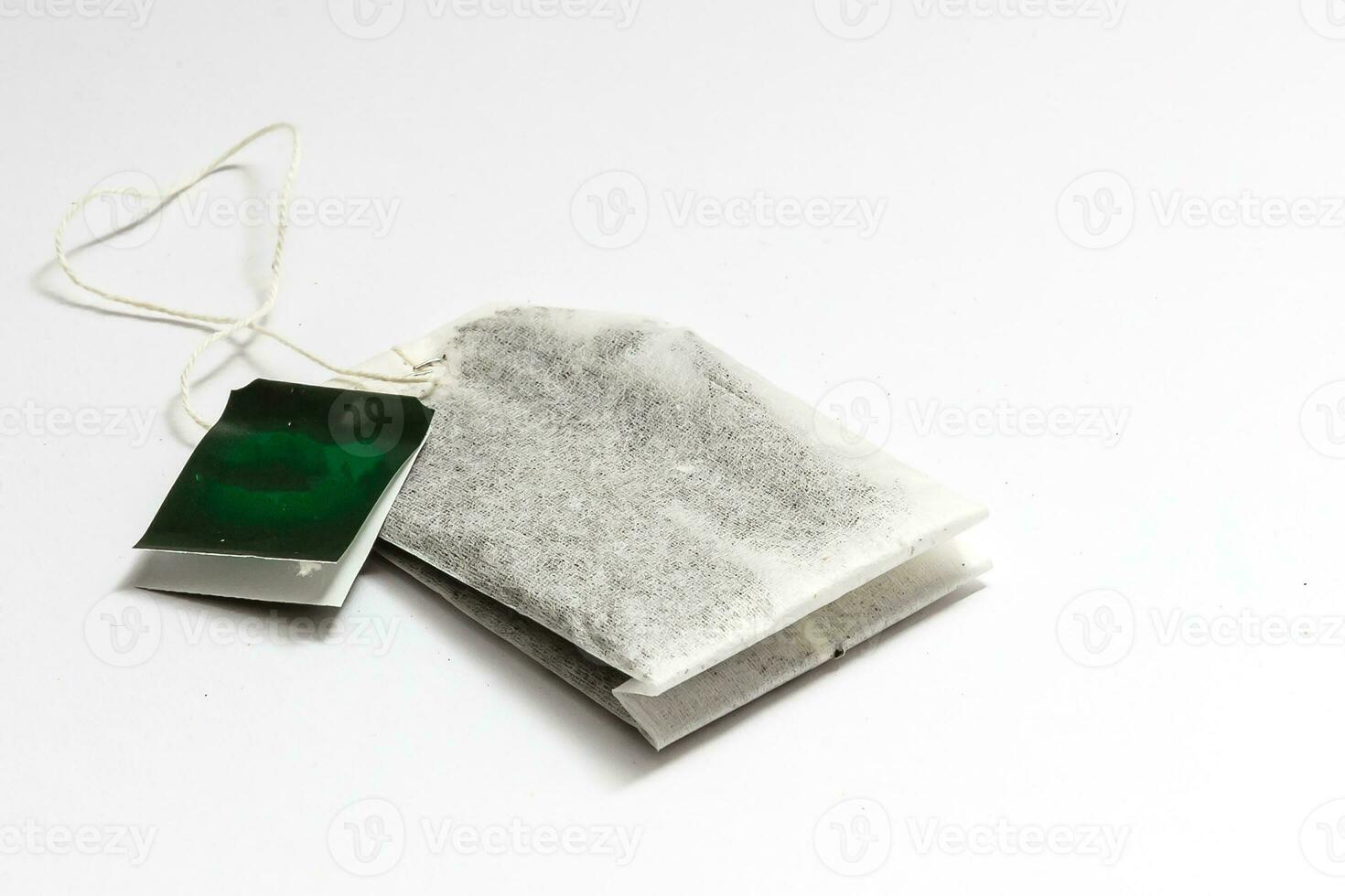 Teabag with green label. Isolated on white background photo