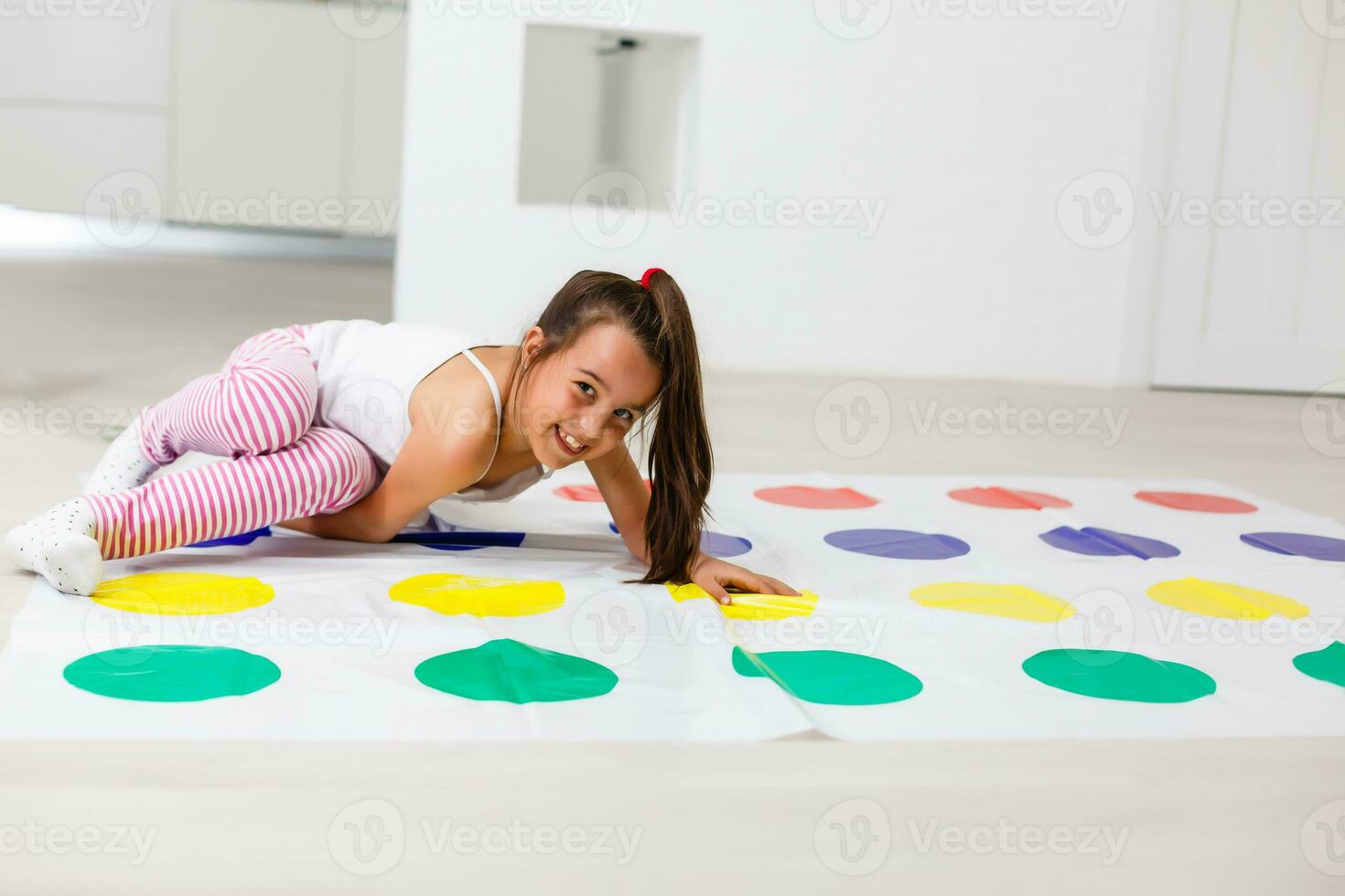 little girl plays twister at home photo