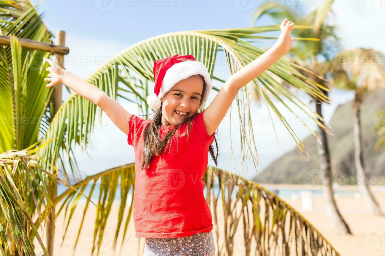 Little adorable girls in Santa hats during beach Christmas vacation photo