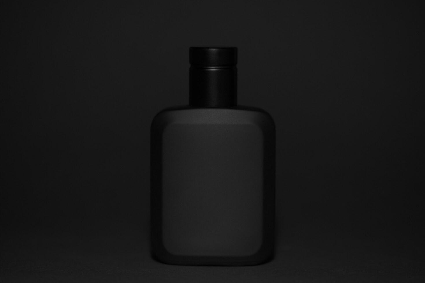 Macro photography of black perfume bottle isolated on black background photo