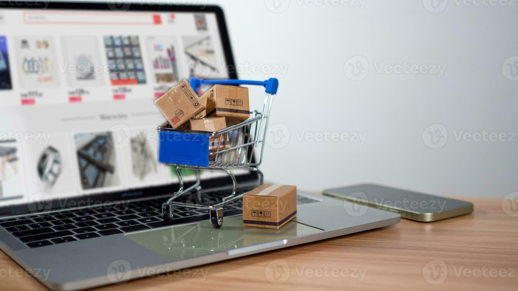 Shopping cart and product boxes placed on laptop computer represent online shopping concept, website, e-commerce, marketplace platform, technology and online payment concept. photo
