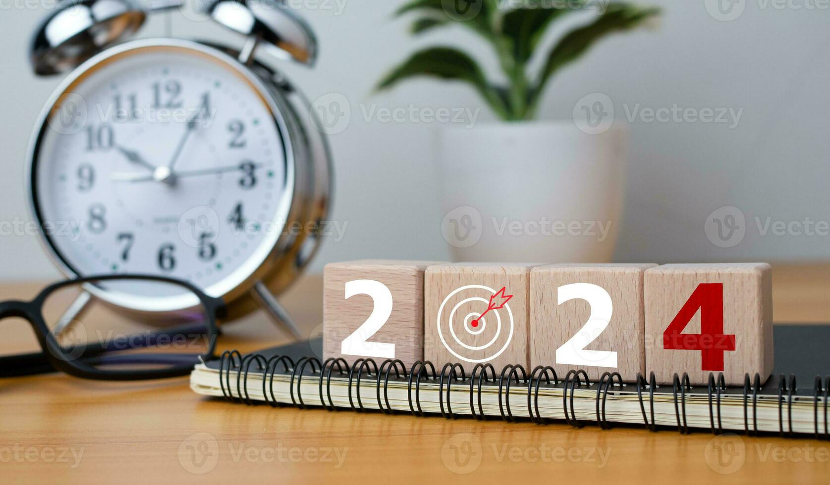 de madera bloques con letras 2024 con calendario y alarma reloj en de madera antecedentes representando el transición a 2024, negocio puesta en marcha plan, el cuenta regresiva comienza a 2024 foto