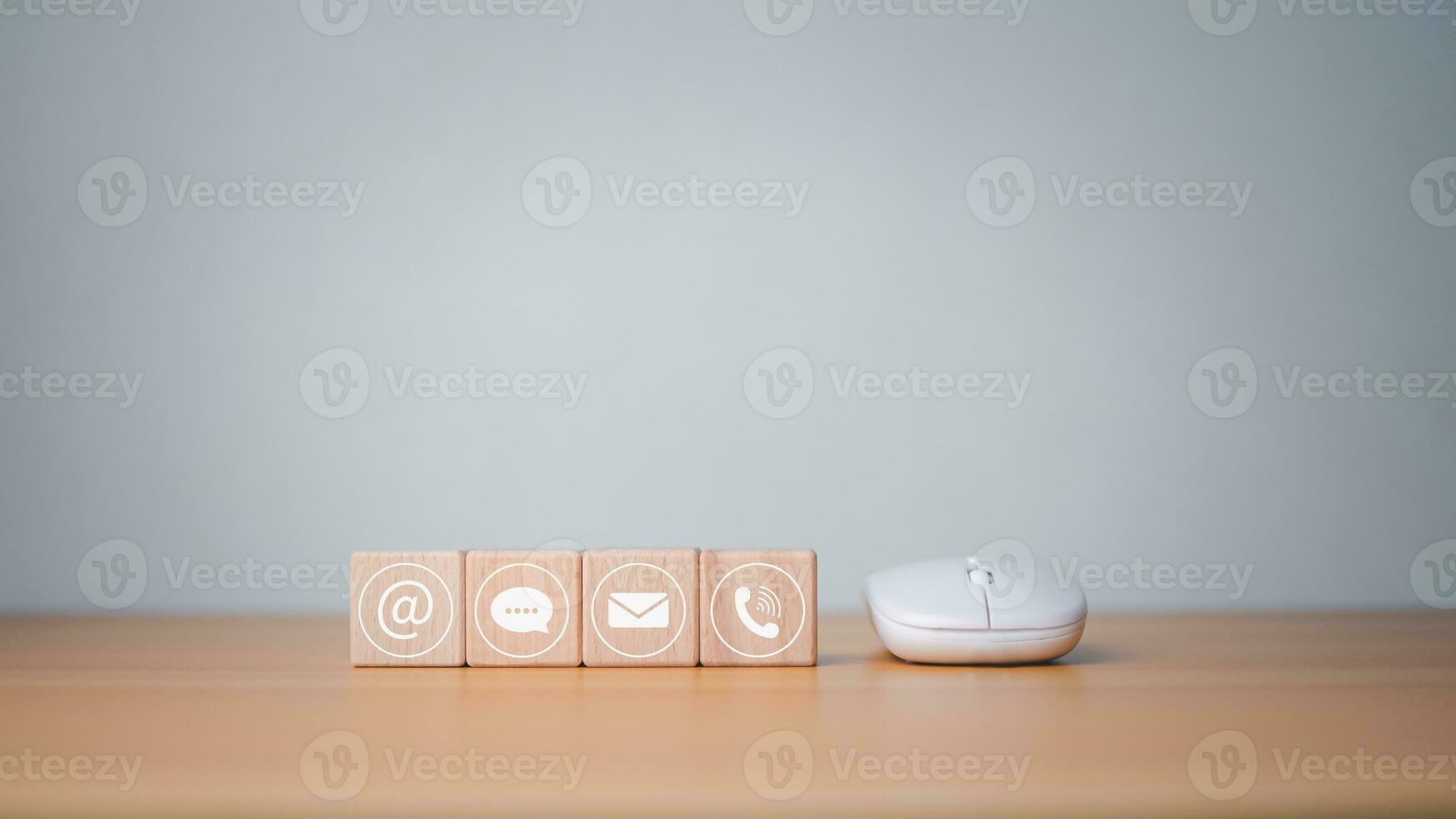 Website page contact us or email marketing concept, customer support hotline, contact us, wooden block printed communication symbol with mouse, email icons, phone, address, chat message. photo