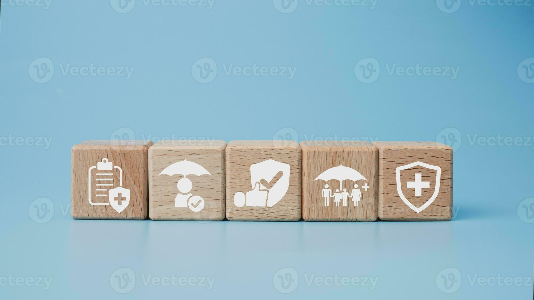 Concept of health insurance and medical. Wooden block with icons about health insurance and access to health care, health care planning on a blue background. photo