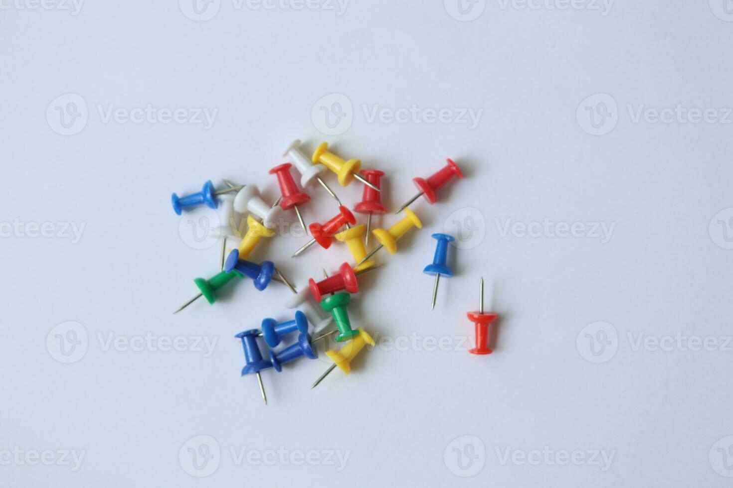 Handy tool with a pointed end and colorful head, used for securing papers on boards or walls with ease. photo