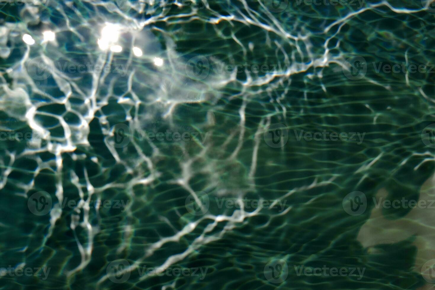 Blue water with ripples on the surface. Defocus blurred transparent white-black colored clear calm water surface texture with splash and bubbles. Water waves with shining pattern texture background. photo