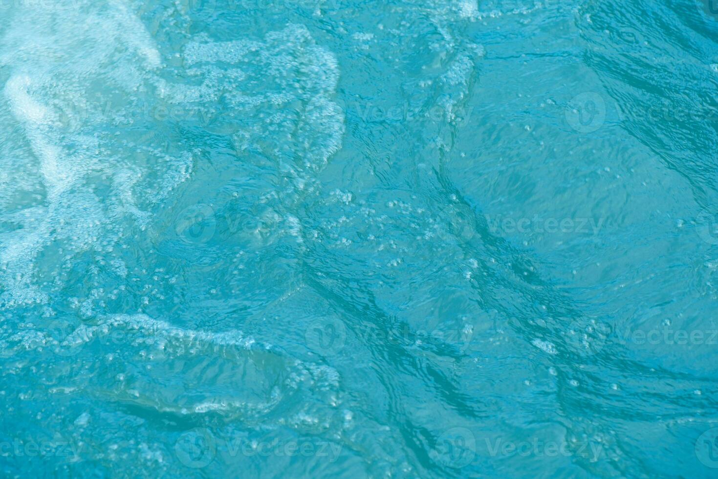 Blue water with ripples on the surface. Defocus blurred transparent white-black colored clear calm water surface texture with splash and bubbles. Water waves with shining pattern texture background. photo
