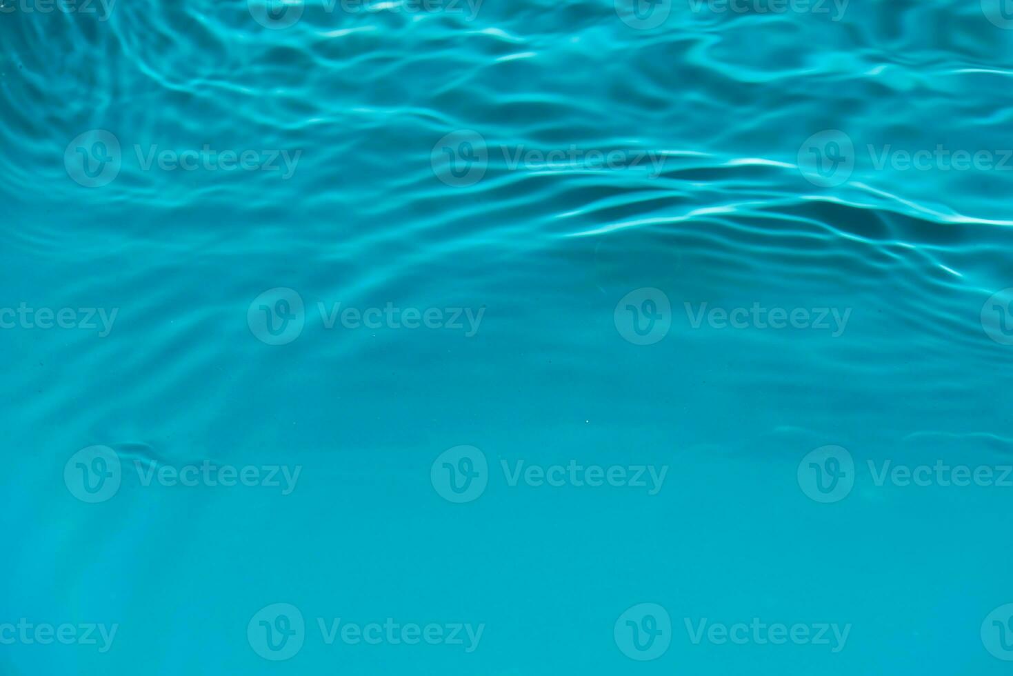 Defocus blurred transparent blue colored clear calm water surface texture with splashes reflection. Trendy abstract nature background. Water waves in sunlight with copy space. Blue watercolor shine. photo