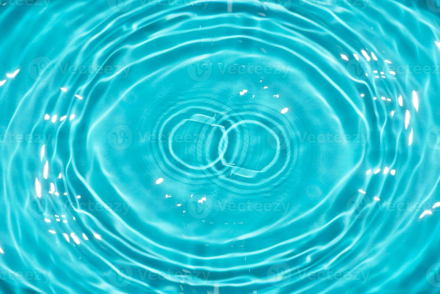 Defocus blurred transparent blue colored clear calm water surface texture with splashes reflection. Trendy abstract nature background. Water waves in sunlight with copy space. Blue watercolor shine. photo