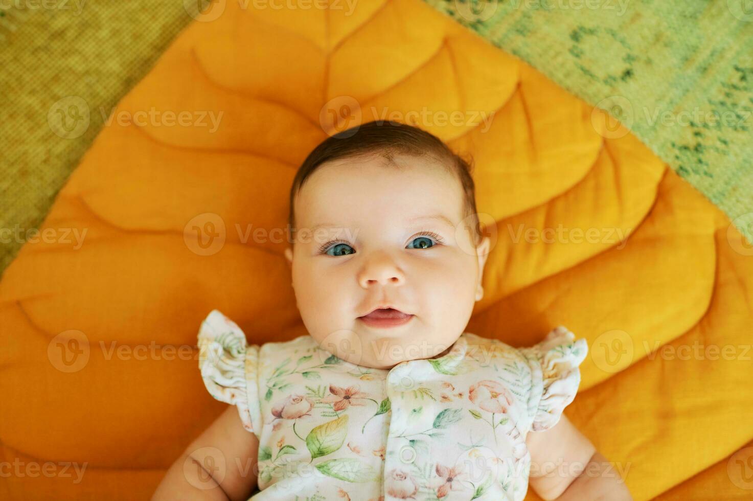 retrato de adorable 6 6 meses antiguo bebé acostado en amarillo jugar cobija foto