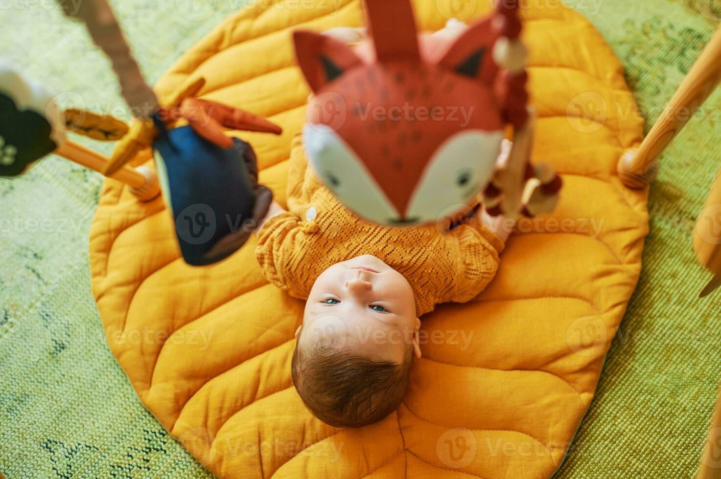 Adorable little baby playing with wooden baby gym photo