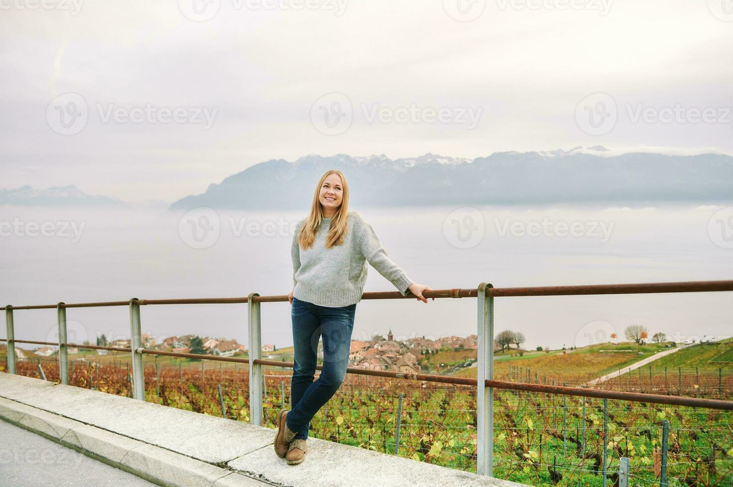 Outdoor portrait of beautiful young woman visiting Lavaux region in late autumn or early spring, canton of Vaud, Switzerland photo