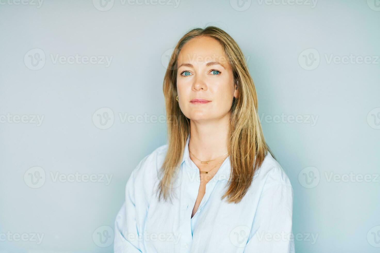 Studio portrait of beautiful young woman on blue background photo