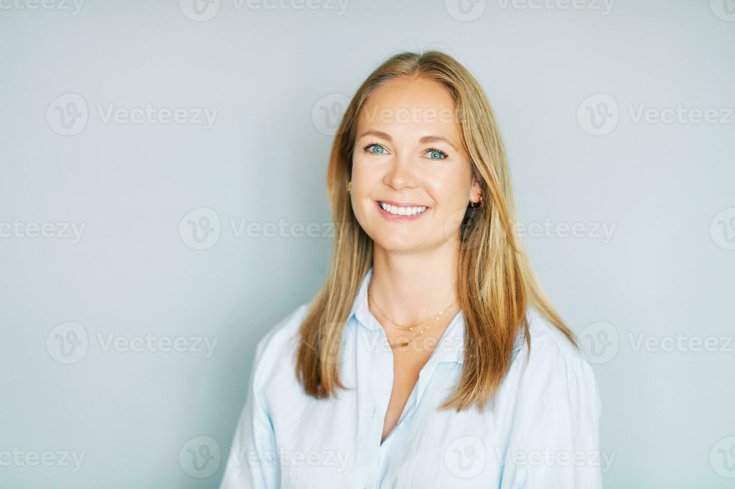 Studio portrait of beautiful young woman on blue background photo