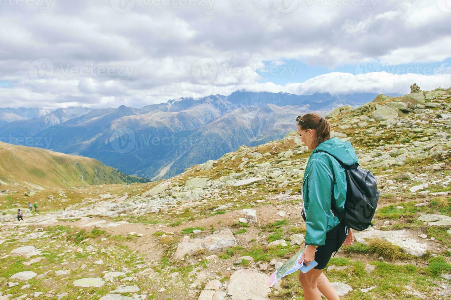 Outdoor portrait of happy young woman hiking in autumn mountains photo