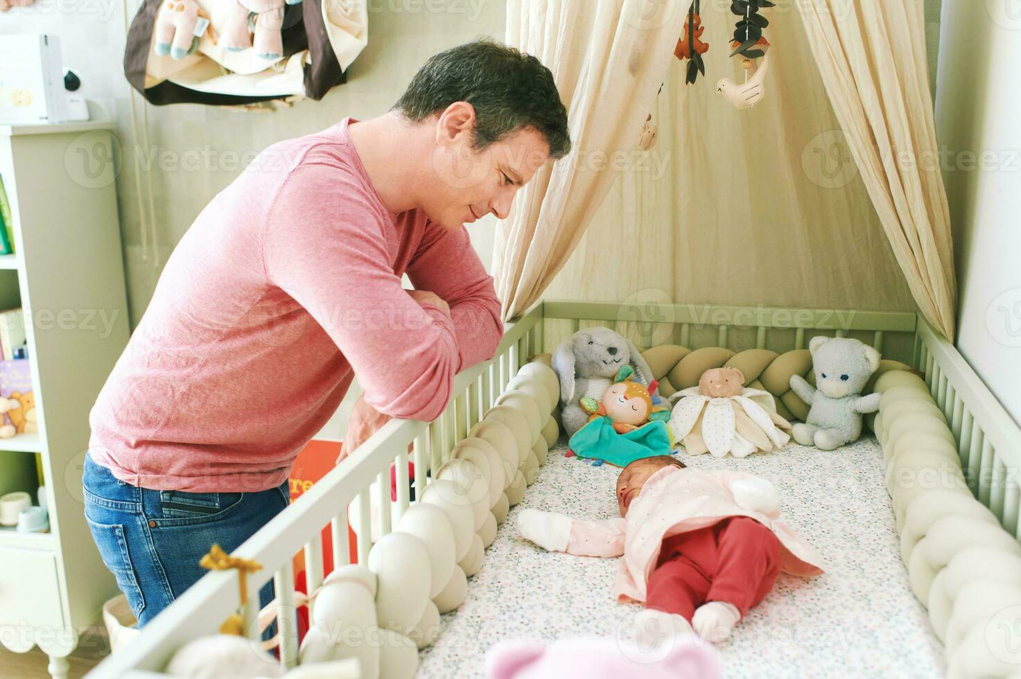 Father admiring how newborn baby sleeping in crib, first days of life photo