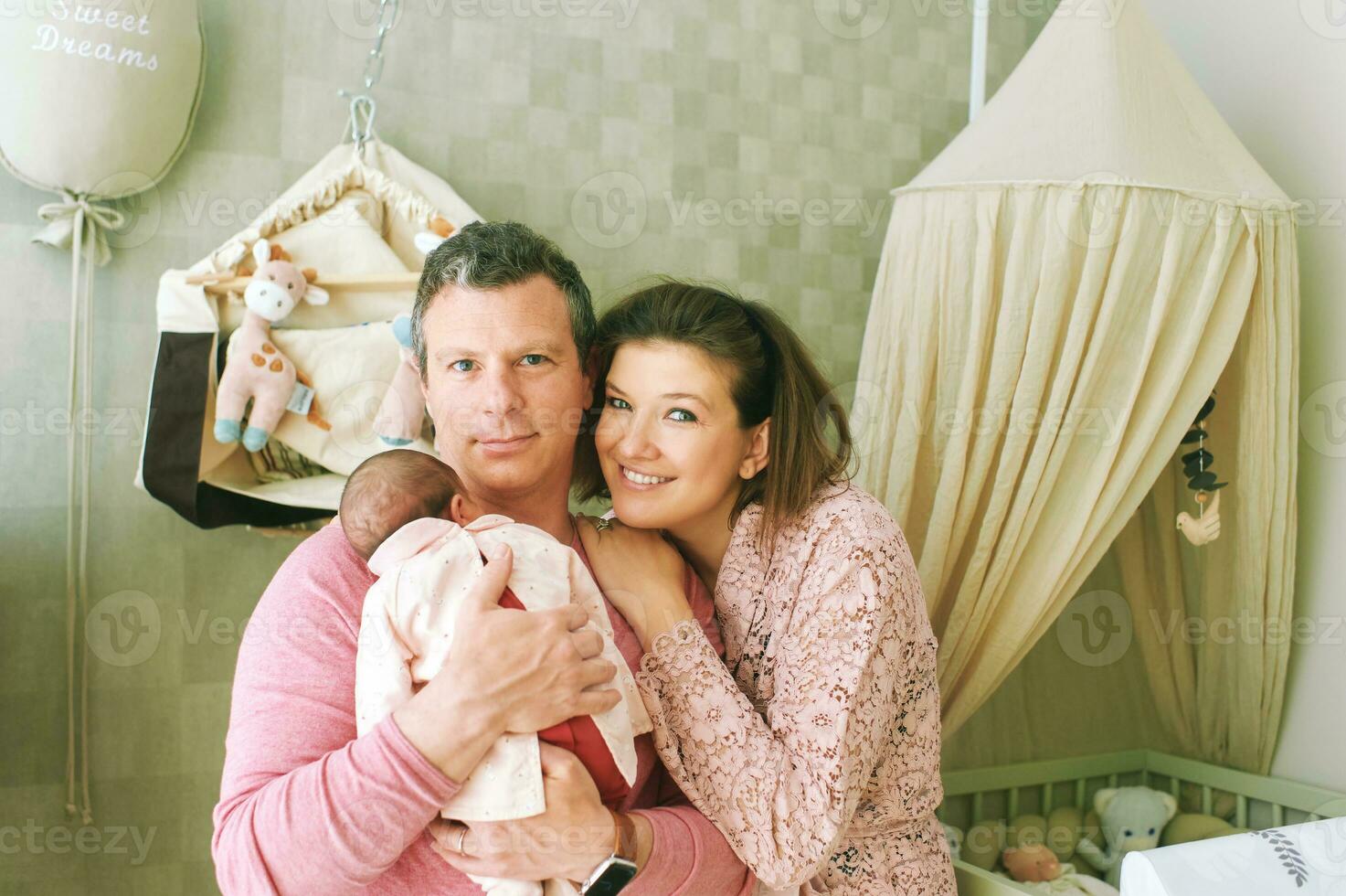 Happy family with baby, first time parents holding newborn daughter photo