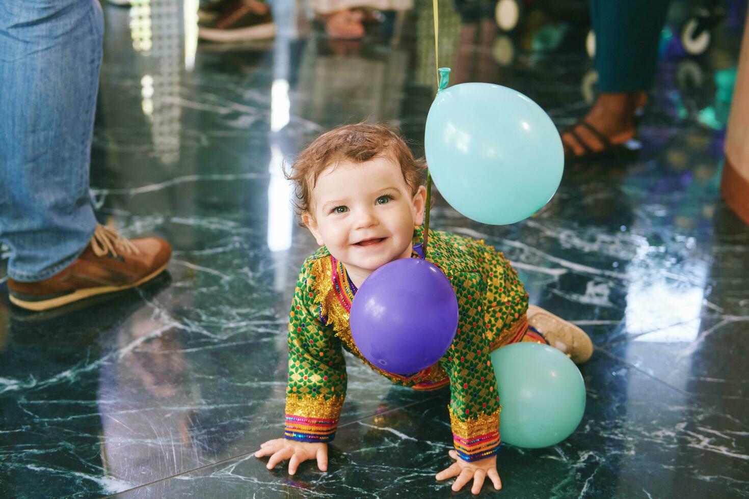 Portrait of adorable baby crawling across the floor at the party, playing with balloons photo