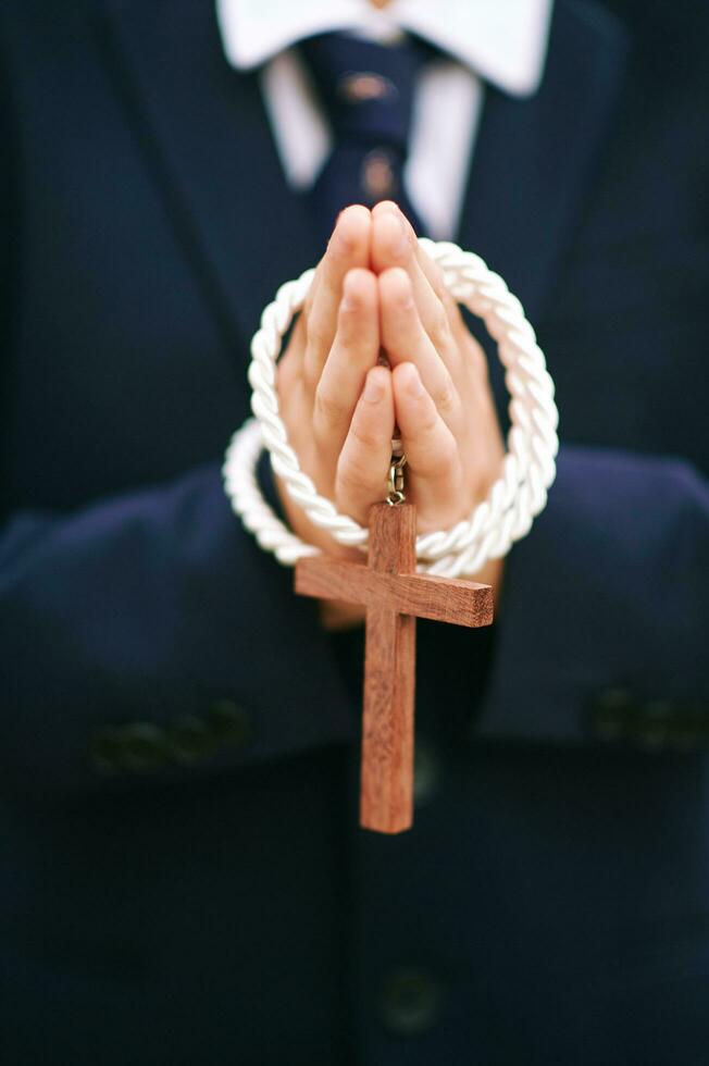 Close up image of child holding cross, first communion photo