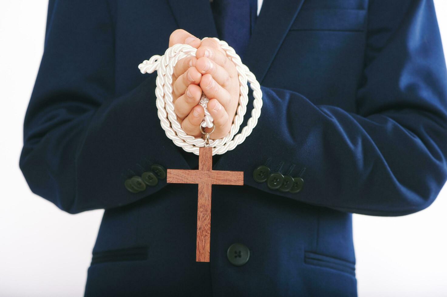 Close up image of child holding cross, first communion photo