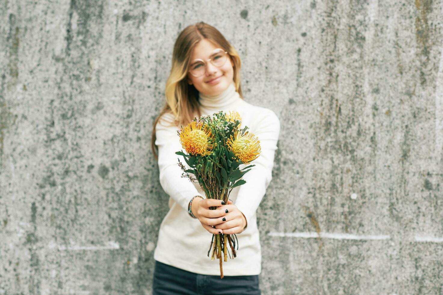 Bouquet of yellow leucospermum flowers holding by young teenage girl, selective focus photo