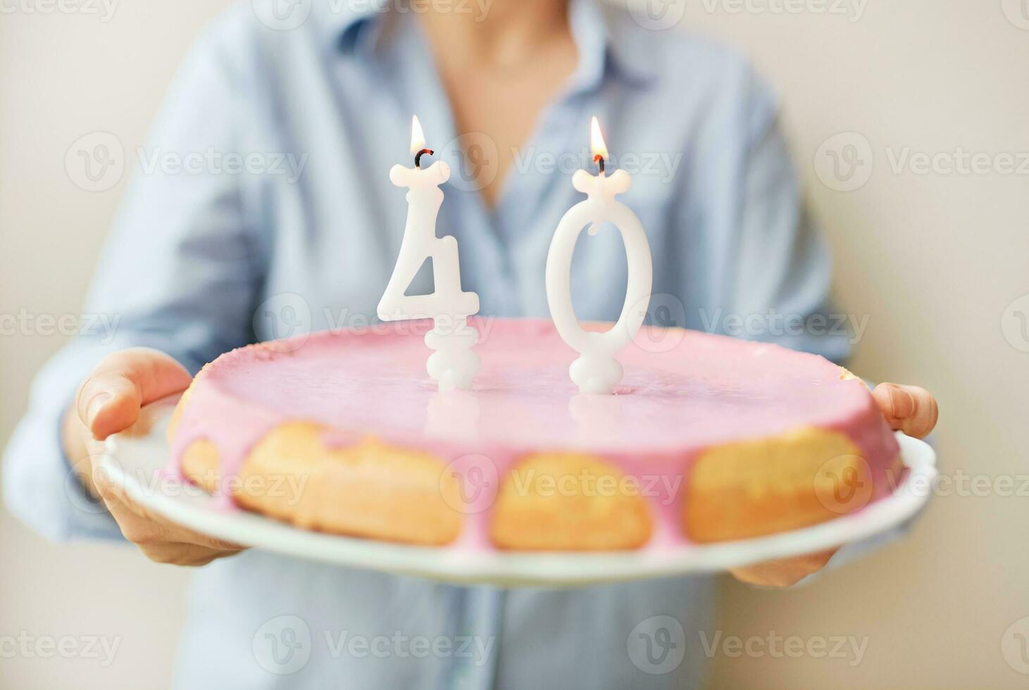 Happy middle age 40 year old woman holding cake with candles photo