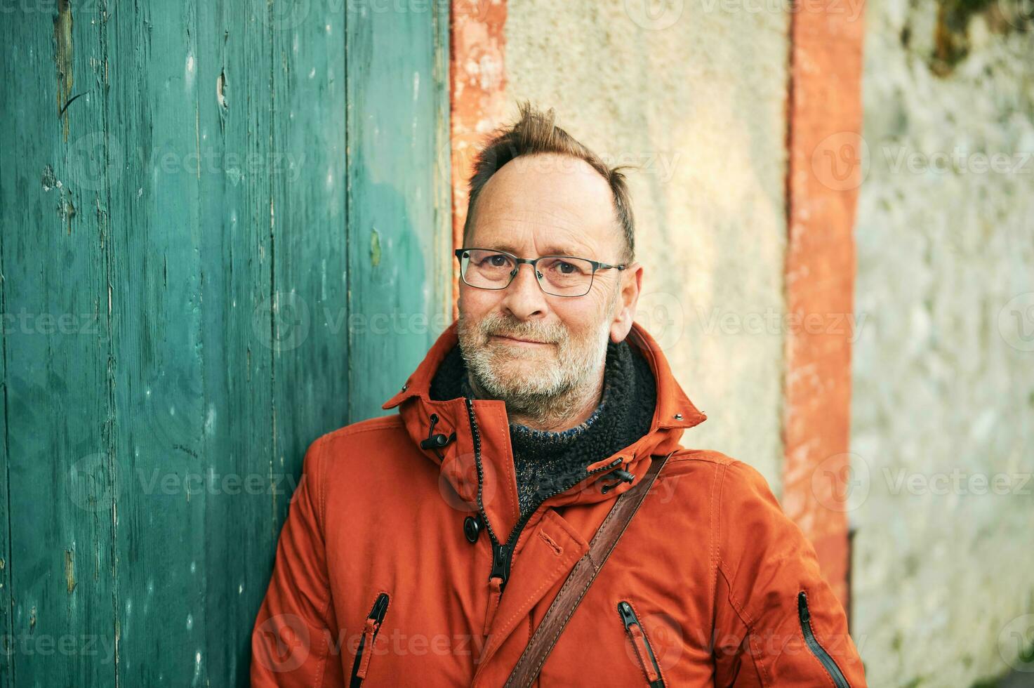 al aire libre retrato de medio años hombre vistiendo los anteojos y naranja invierno chaqueta foto