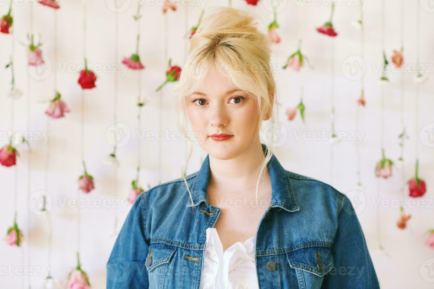 estudio retrato de bonito joven Adolescente 15 - dieciséis año antiguo niña vistiendo mezclilla chaqueta, posando en blanco antecedentes con colgando flores, belleza y Moda concepto foto