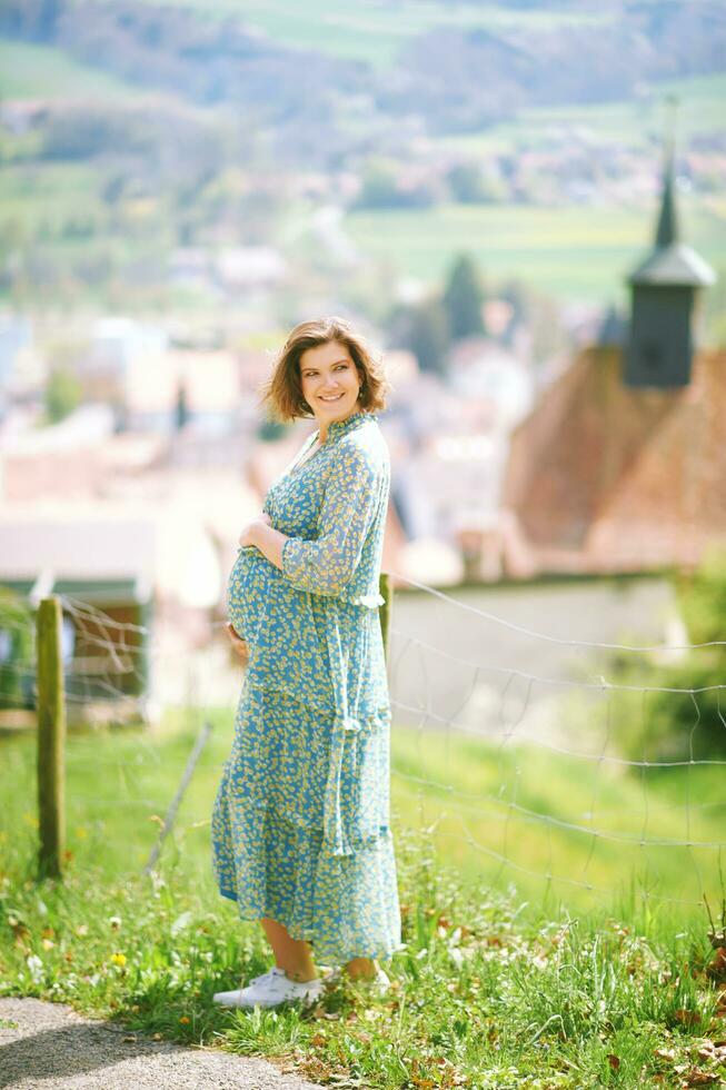 Outdoor maternity portrait of happy young woman travel in Europe photo