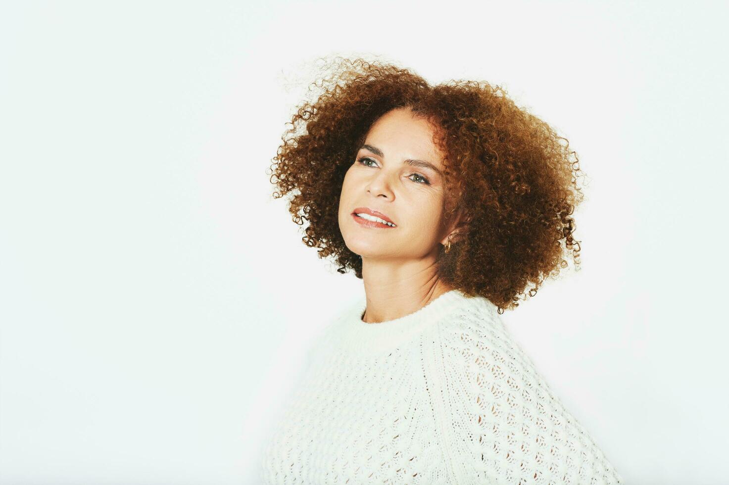 Studio portrait of beautiful middle age woman posing on white background, wearing pullover photo