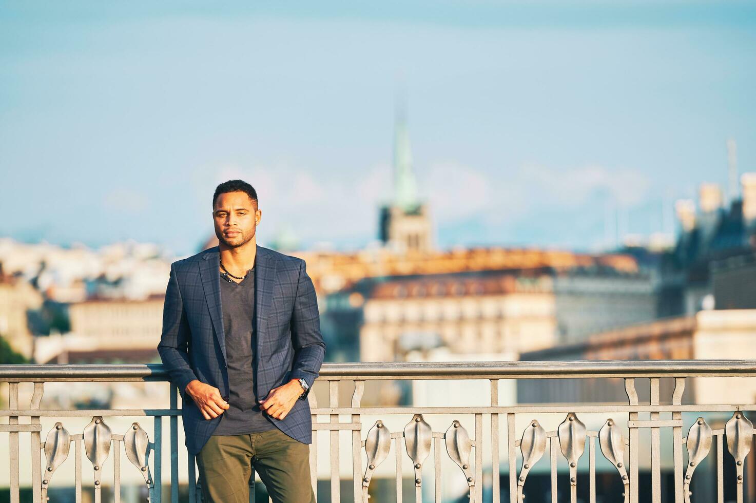 Outdoor portrait of handsome afro american man, city landscape on background photo