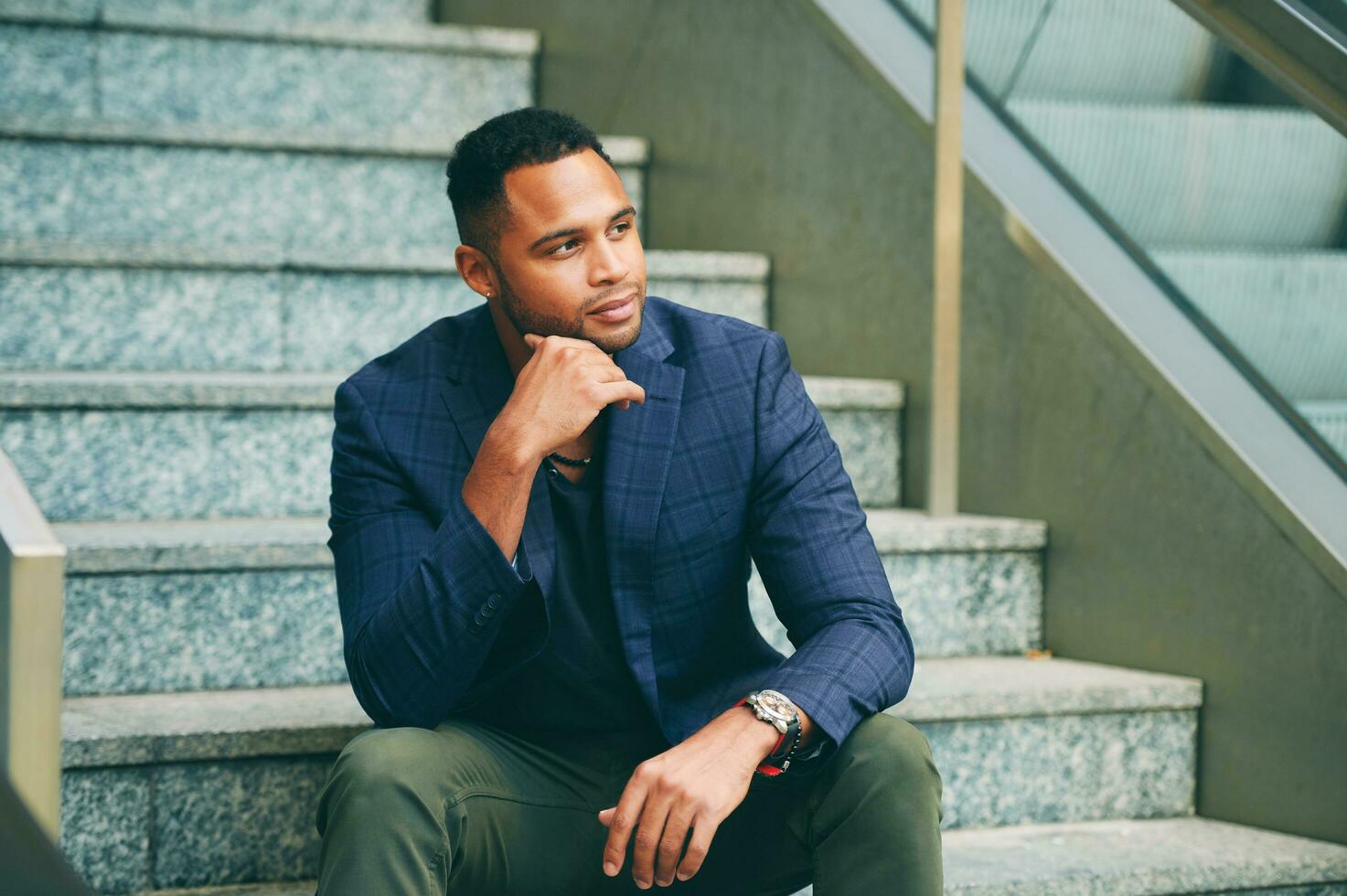 Outdoor urban portrait of African American male model sitting on stairs photo