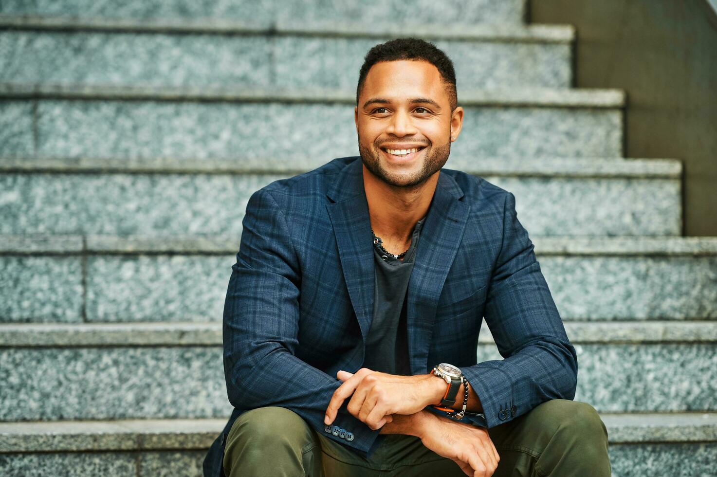 Outdoor urban portrait of African American male model sitting on stairs photo