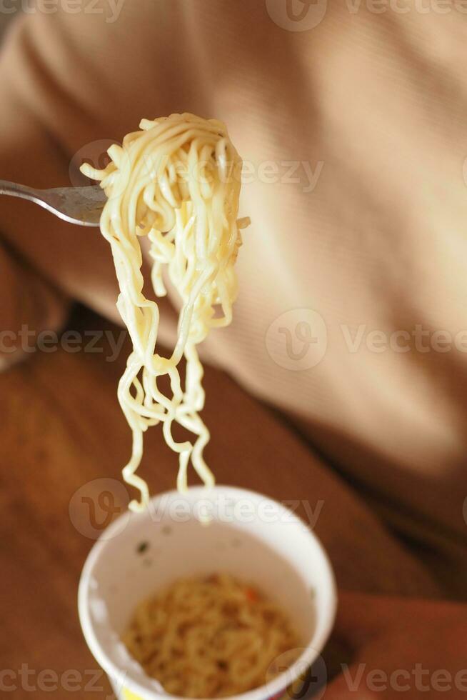 women eating instant noddles at home photo