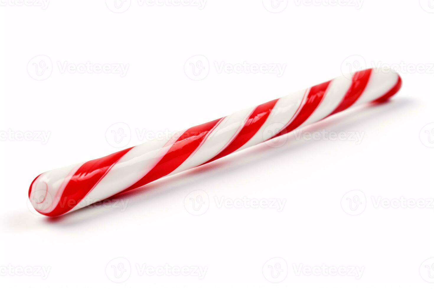 A candy cane is pictured against a white backdrop. photo