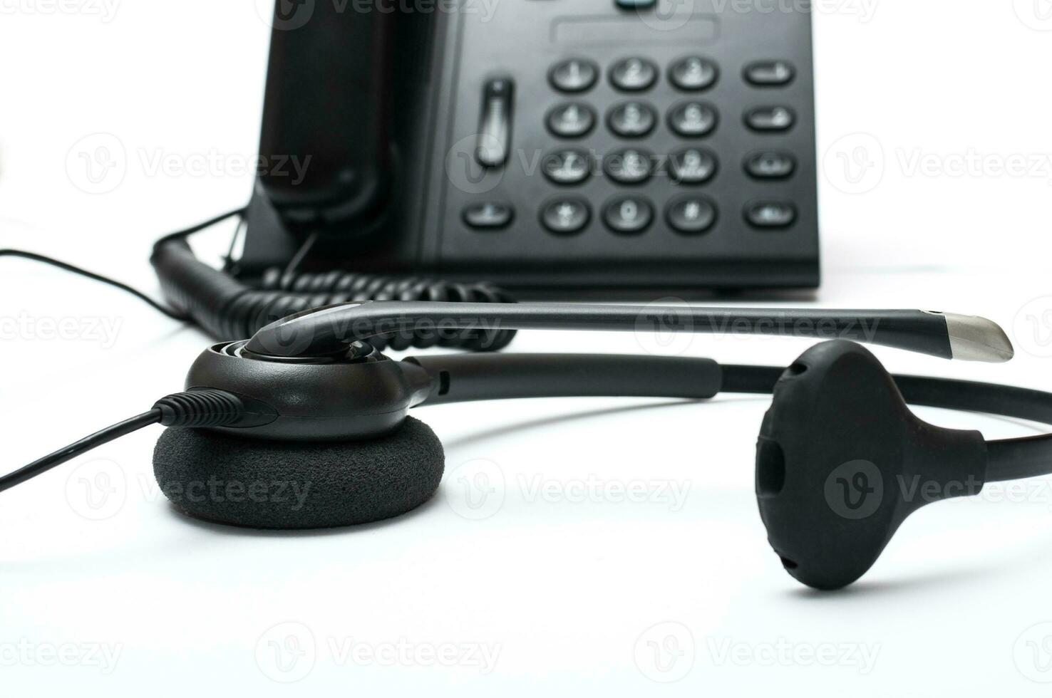 Black desktop phone with a headset on the white background photo