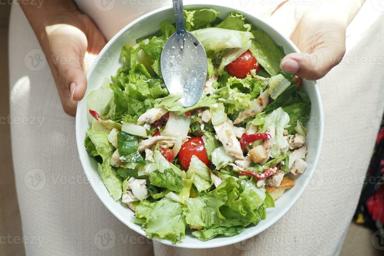 top view of women holding a bowl of fresh salad at home photo