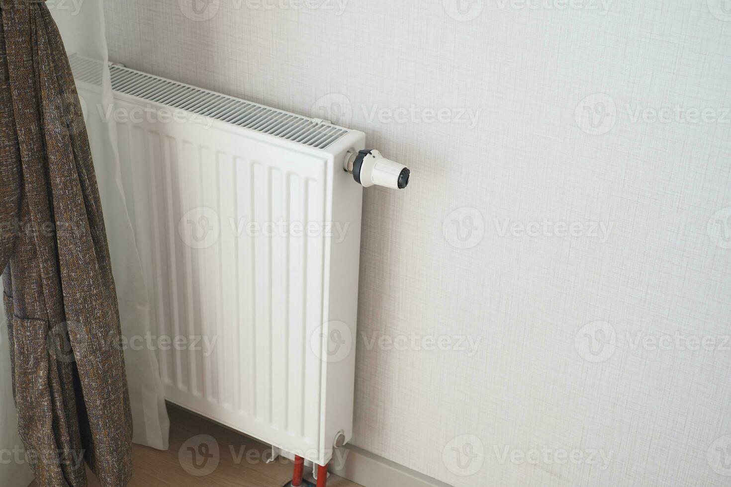 White radiator on grey white wall. apartment heating installation system, photo