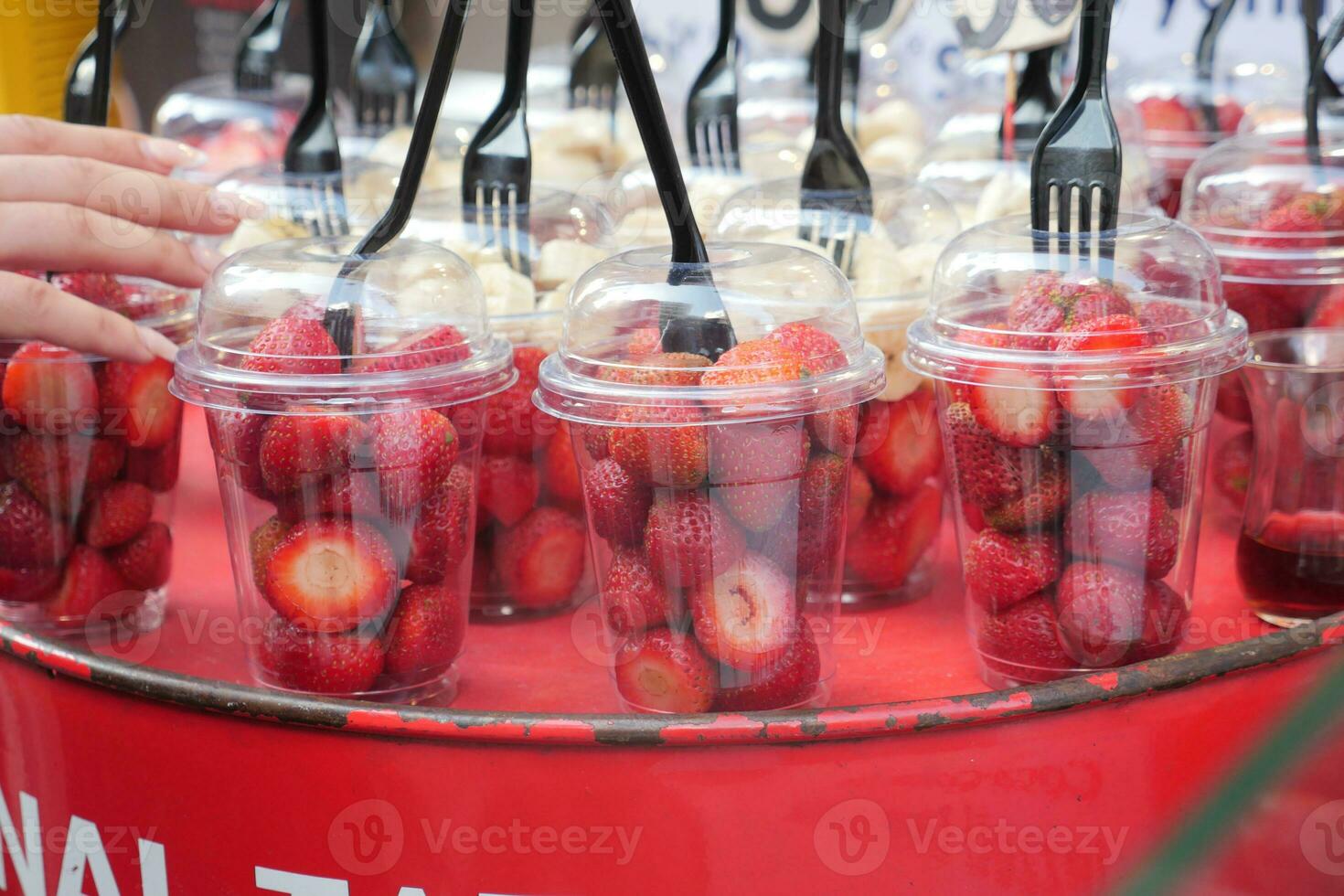 Ripe Red Strawberries in. plastic container selling at shop photo