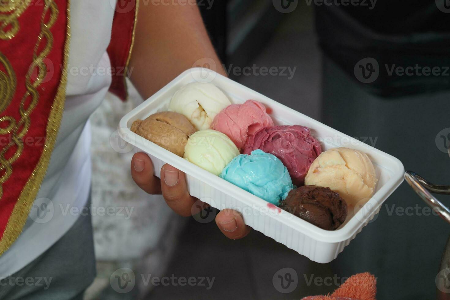 hombres poniendo diferente sabor hielo crema en un el plastico envase foto